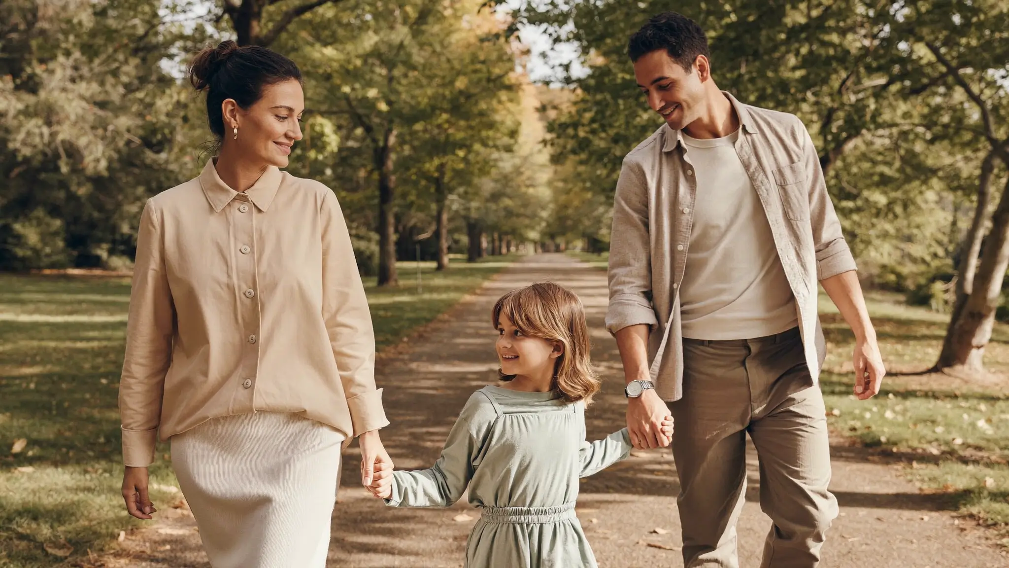 Un genitore, il nuovo compagno e un bambino che passeggiano al parco